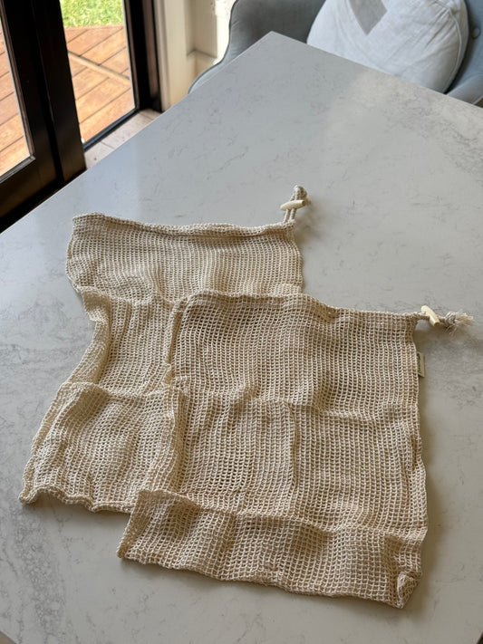 Two organic cotton mesh produce bags, medium and large, on our kitchen bench in Bayside