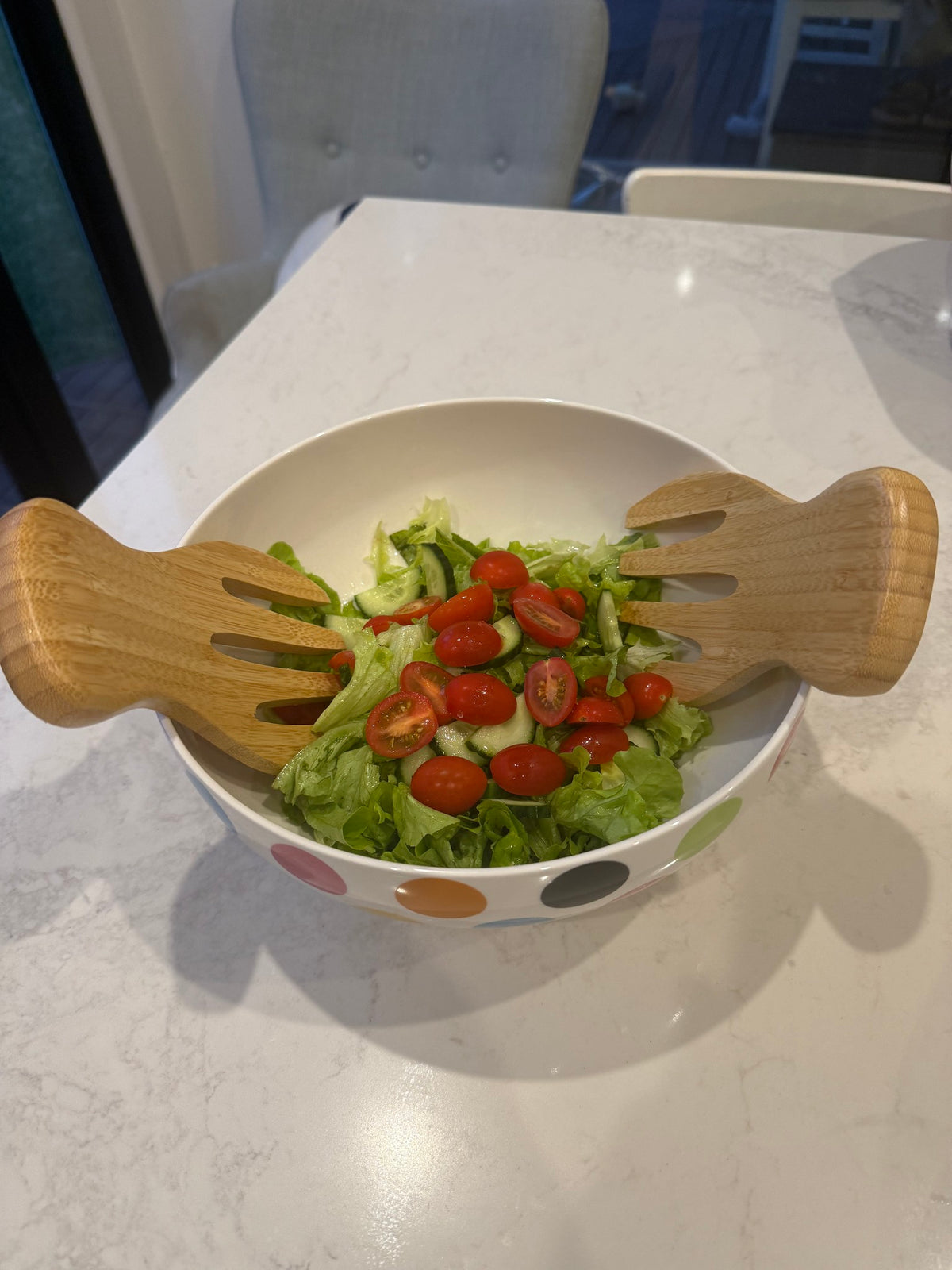 Bamboo salad hands in a bowl of salad