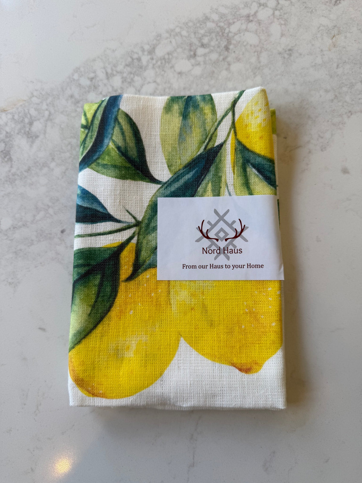 Nord Haus Lemons linen tea towel folded, on our kitchen bench in Bayside