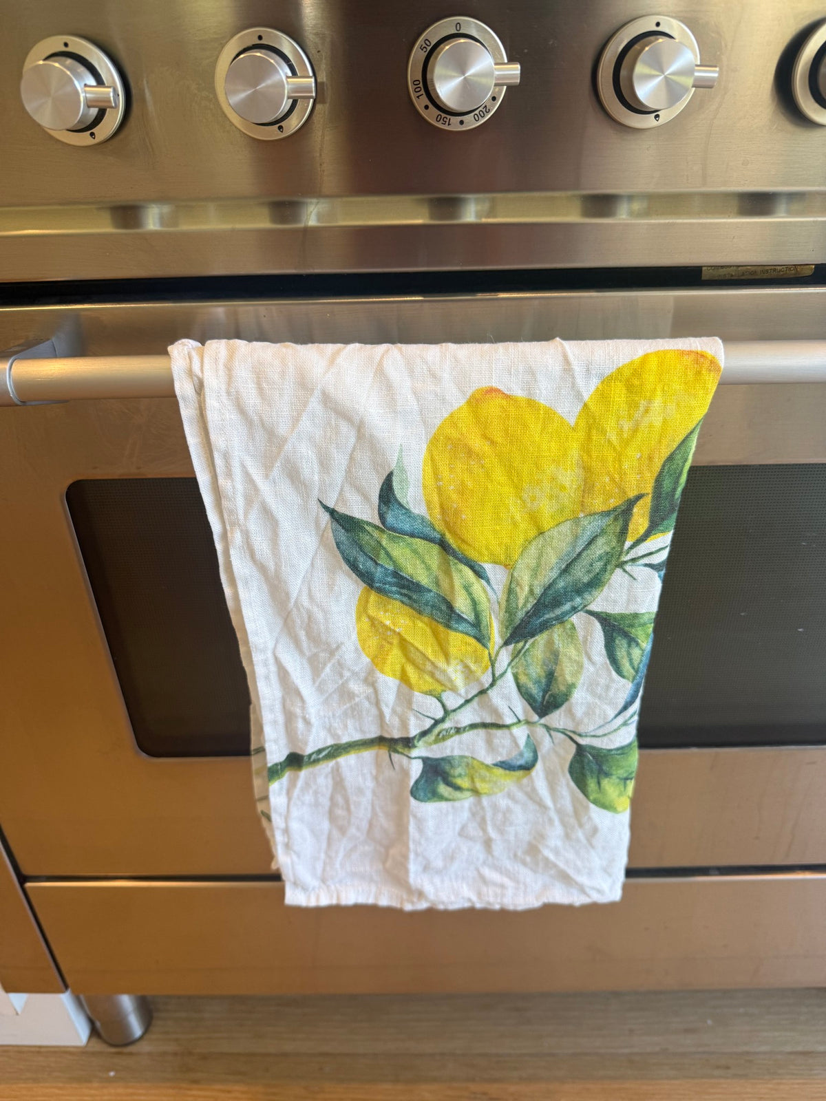 Lemons linen tea towel hanging on our oven door