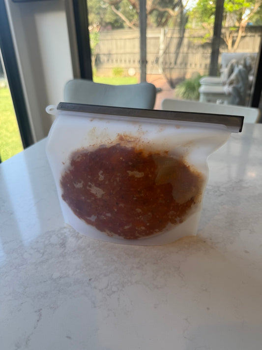 1L silicone bag standing up, filled with leftovers